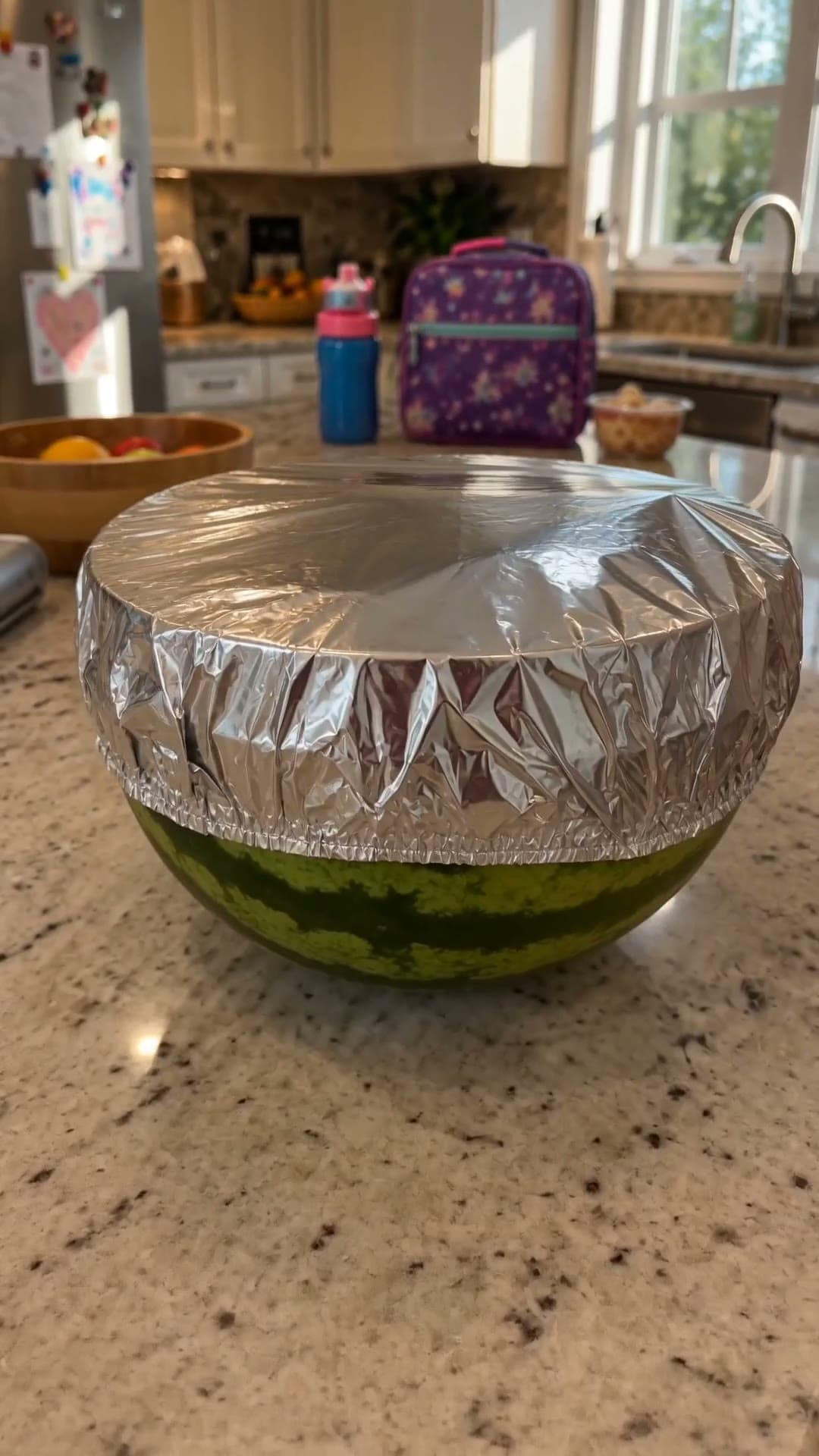 A half watermelon sealed with a flexible foil cover